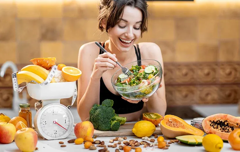 a woman smiling while eating a salad - Stress Relief Therapies